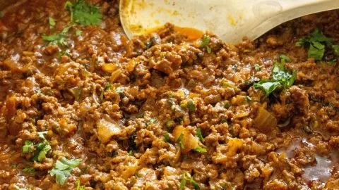 Delicious ground beef curry served in a bowl with spices and herbs.