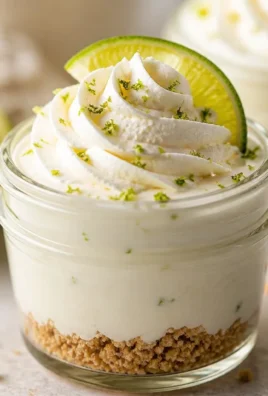 Key Lime Pie Mason Jar dessert topped with whipped cream and lime zest