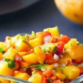 Fresh peach mango salsa served in a bowl with colorful ingredients