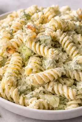 Creamy dill pickle pasta salad served in a bowl with fresh ingredients.