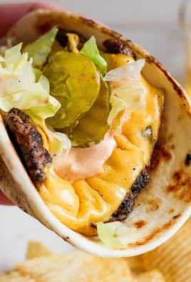 Smash Burger Taco topped with delicious burger sauce on a wooden table