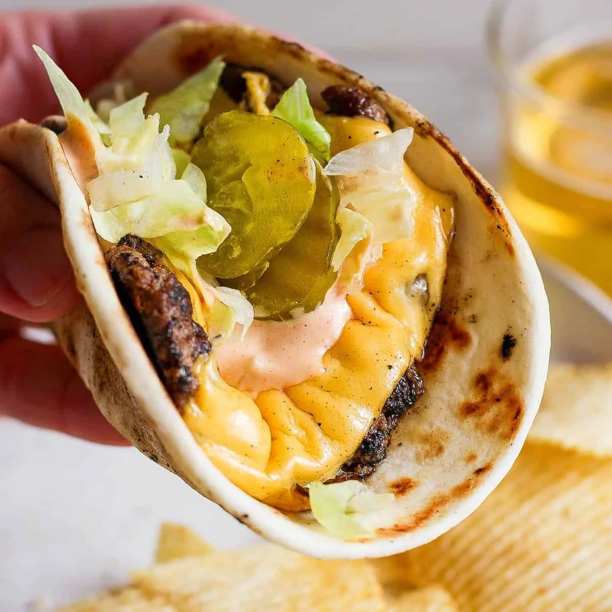 Smash Burger Taco topped with delicious burger sauce on a wooden table