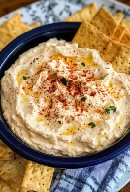 Bowl of spicy Alabama Fire Cracker Dip with crackers and fresh ingredients