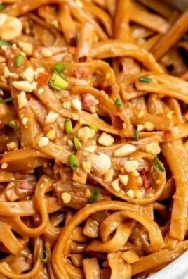 Delicious bowl of Spicy Peanut Butter Noodles with vibrant vegetables.