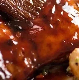 Delicious sticky grilled chicken garnished with herbs and spices.