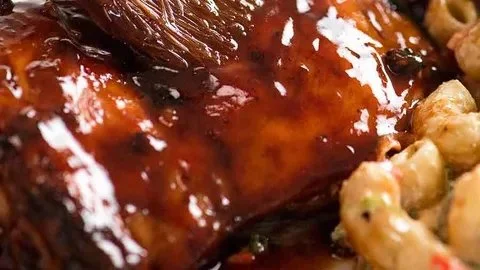 Delicious sticky grilled chicken garnished with herbs and spices.