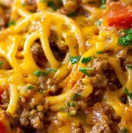 Delicious Taco Spaghetti topped with cheese and vegetables in a bowl