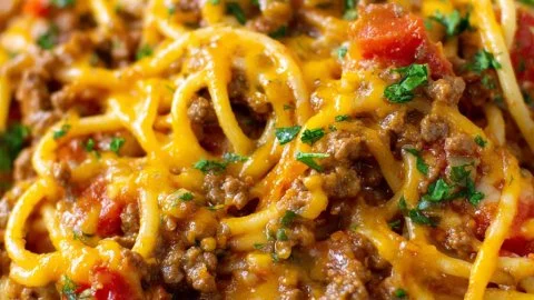Delicious Taco Spaghetti topped with cheese and vegetables in a bowl