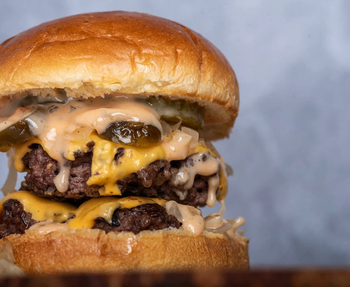Delicious homemade smash burger with toppings on a wooden table