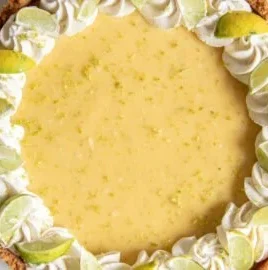 Slice of traditional key lime pie on a plate with lime slices decor