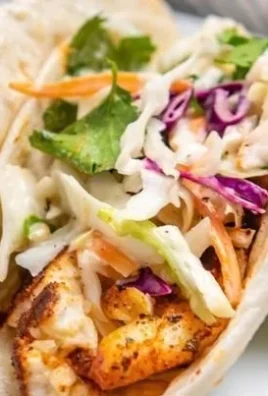 Delicious air fryer fish tacos plated with fresh toppings and lime wedges