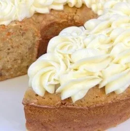 Slices of moist Carrot Pound Cake on a plate, garnished with cream cheese frosting.