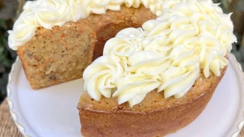 Slices of moist Carrot Pound Cake on a plate, garnished with cream cheese frosting.