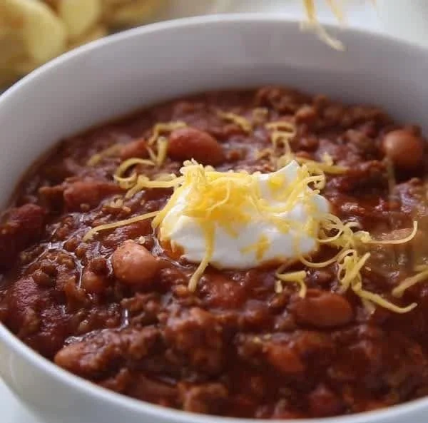 Bowl of classic homemade chili topped with cheese and cilantro