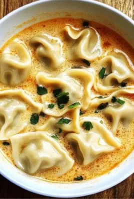 Creamy Thai dumpling soup served in a bowl with herbs and spices.