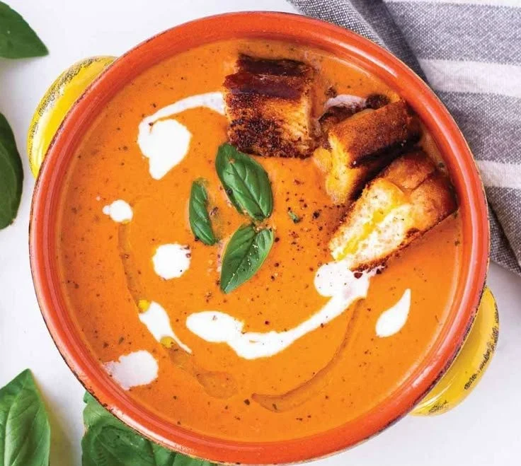 Bowl of creamy tomato basil bisque garnished with fresh basil leaves