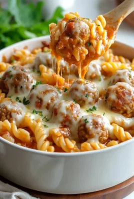 Delicious Dump and Bake Meatball Casserole topped with cheese and herbs in a baking dish.