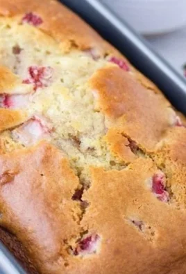 Slices of fresh strawberry quick bread with strawberries on the side