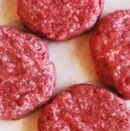 Delicious homemade hamburger patty on a grill ready to serve