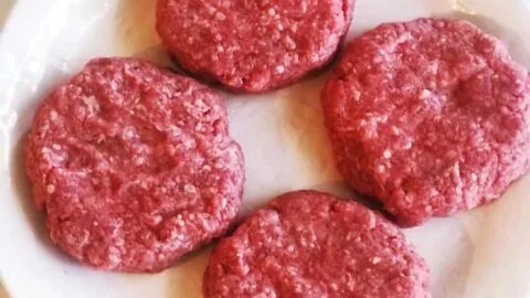 Delicious homemade hamburger patty on a grill ready to serve