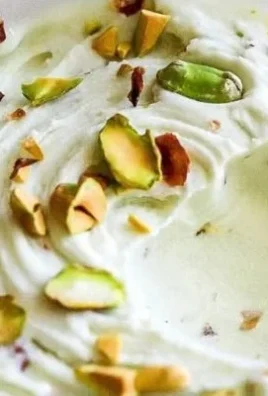 Ninja Creami pistachio ice cream in a bowl topped with crushed nuts