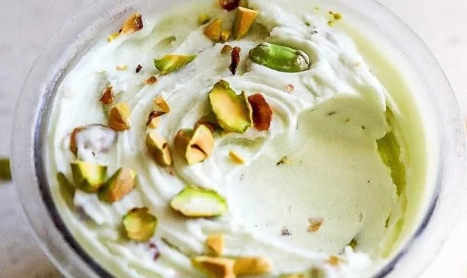 Ninja Creami pistachio ice cream in a bowl topped with crushed nuts