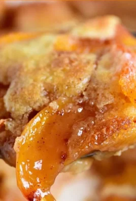 Delicious homemade peach cobbler served warm with a scoop of vanilla ice cream.