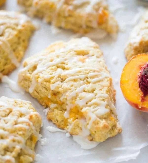 Freshly baked peach scones on a plate with a hint of glaze