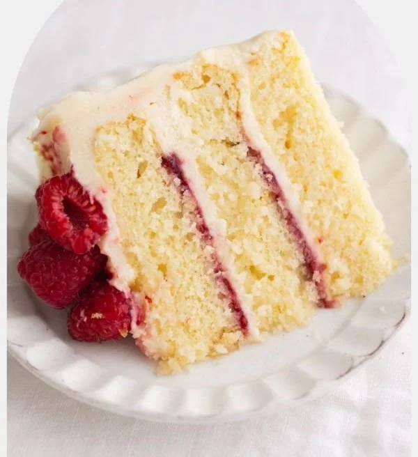 Delicious Raspberry Lemon Cake adorned with fresh raspberries and lemon slices.