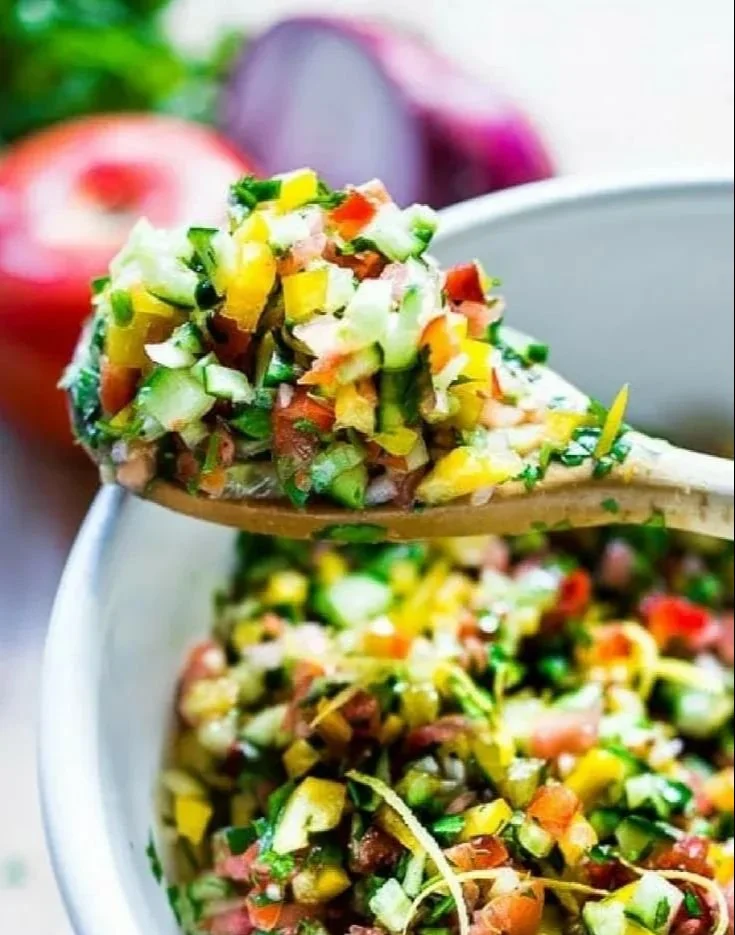 A colorful bowl of simple healthy Israeli salad with fresh vegetables.